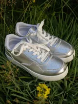 Championes urbanos Champion modelo Lina, color plateado con suela blanca y cordones blancos.