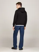 Buzo con capucha y cordón ajustable Tommy Hilfiger de color negro, con bolsillo tipo canguro y detalle de franja horizontal tricolor en el pecho con el nombre de la marca.