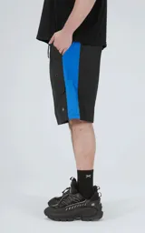 Bermuda de tela liviana de secado rápido, color negro con paneles laterales en azul eléctrico. Posee cintura elástica con cordón de ajuste estampado y bolsillos laterales y un bolsillo cargo con solapa en la pierna derecha.
