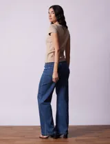 Remera color beige de tejido acanalado, con escote a la base y manga corta.