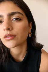 Aros dorados con dije circular de piedra natural negra.