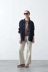 Remera negra de manga corta con estampado botánico en azul y la frase "NOTHING GROWS IN COMFORT".