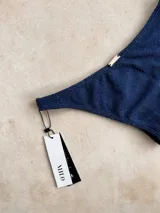 Bombacha de bikini vedetina con estampado geométrico en tonos naranja, celeste y rosa.