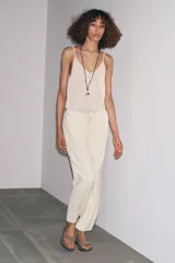 Pantalón jogger de la colección Zara Woman, color gris claro, confeccionado en hilatura con algodón y lyocell. Presenta tiro medio, cintura elástica ajustable con cordones, bolsillos laterales ocultos en costura y pierna ancha.