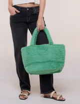 Cartera tipo shopper verde de textura suave y flexible, con doble asa superior fija texturada y compartimento principal amplio con botón metálico.