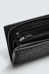Cartera negra rectangular con diseño trenzado y correa fina para colgar.