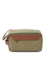 Neceser de diseño rectangular confeccionado en tela canvas color verde oliva con detalles en cuero sintético marrón. Cuenta con asa de mano lateral, cierre superior y bolsillo frontal con solapa.