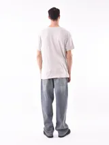 Remera color arena con cuello redondo y estampado pequeño en el pecho.