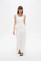 Pantalón blanco de viscosa, de corte ancho y tiro alto, con bolsillos laterales.