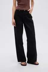 Pantalón jean negro de tiro alto con diseño a rayas y corte baggy de pernera ancha.