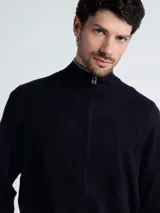 Campera de punto tipo sweater con cierre frontal completo, cuello alto y detalles en color gris en el borde del cuello, puños y ruedo.