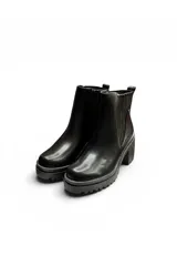 Bota corta tipo chelsea color negro, con elástico lateral estriado, plataforma dentada y taco ancho.