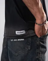 Remera negra con efecto deslavado acid wash, corte oversize y mangas cortas. Presenta un pequeño estampado frontal en el pecho.