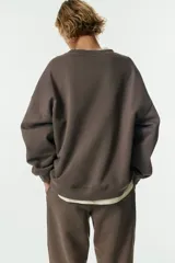 Buzo oversized de cuello redondo con interior cepillado suave, hombros caídos y puños y bajo acanalados.