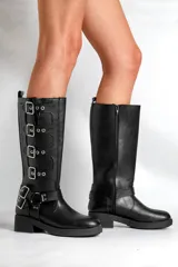 Borcegos negros de caña alta confeccionados en cuero sintético, con hebillas plateadas en los costados y cierre lateral. La altura de la caña es de 33,5 cm y la base mide 5 cm.