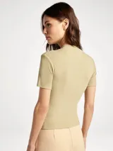 Blusa de cuello alto y manga corta, confeccionada en tela acanalada de ajuste entallado.