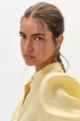 Camisa color amarillo claro de lino, con cuello mao, mangas abullonadas 3/4 y cierre frontal con botones.