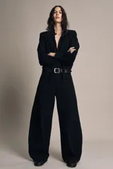 Pantalón de jean negro de tiro bajo, corte amplio tipo balloon, con cinco bolsillos y cierre frontal con cremallera y botón.