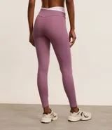 Calza deportiva color lila con cintura alta en V bicolor, confeccionada en microfibra ligera.