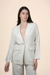 Blazer de lino y viscosa color beige con calce relajado, solapa clásica, cierre de un botón y bolsillos delanteros con solapa.