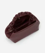Bolso de mano pequeño color borgoña, con cuerpo de forma trapezoidal y asas cortas trenzadas. El material parece ser cuero sintético (PU).