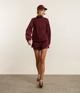 Campera rompevientos deportiva de mujer, marca Get Over, color beige con sutiles rayas verticales, cuello alto, cierre frontal con cremallera y puños ajustados.