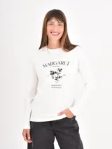 Remera de manga larga en color blanco con estampado gráfico floral y tipografía en el centro del pecho.