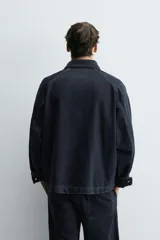 Cazadora de denim de algodón con efecto lavado, cuello solapa, manga larga y cierre frontal con cremallera oculta por solapa con botones a presión. Presenta bolsillos de plastrón con solapa en el delantero.