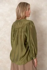 Camisa de organza blanca con cuello mao, diseño de manga larga tipo murciélago y cierre frontal con botones. Presenta un corte holgado y fluido.