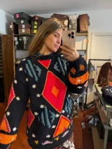 Sweater de punto negro tejido a mano con diseño geométrico multicolor y detalles bordados en contraste.