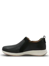 Zapatillas slip on Hush Puppies modelo Spinal Slip On, color negro, confeccionadas en cuero con detalles de gamuza y cierre lateral decorativo. Poseen suela blanca y base de goma con tecnología TripleDensity para mayor amortiguación y soporte.