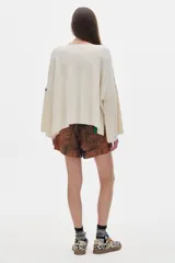 Buzo crop negro de tejido de punto, con cuello redondo y mangas largas amplias.