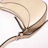 Bandolera dorada en forma de medialuna con correa fina al tono.