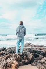 Hoodie gris con estampado en la espalda que incluye texto y dibujos.