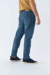 Pantalón jean de calce regular, color celeste con efecto lavado y roturas.