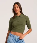 Blusa de punto texturizado color verde militar, con cuello polo, cierre frontal de tres botones y mangas cortas.