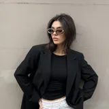 Lentes de sol con armazón de diseño ovalado y estilo envolvente, combinando tonos marrón oscuro y negro. Cuentan con protección UV400.