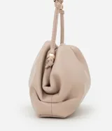 Cartera transversal pequeña color beige, confeccionada en poliuretano con diseño fruncido y asa fina de cordón con detalles metálicos.