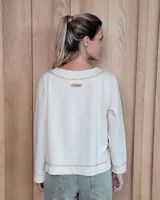 Remera de manga larga color marrón chocolate, con cuello redondo y dos bolsillos frontales tipo parche.