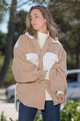 Camisa de pana color beige con detalles en blanco, de corte oversize, con cuello clásico, cierre frontal con botones y bolsillos de parche en el pecho.