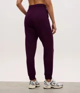 Pantalón tipo jogger de mujer, confeccionado en tejido modal con mezcla de poliéster y elastano. Presenta cintura elástica con lazo de ajuste, bolsillos laterales y puños elásticos en el ruedo.