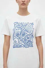 Remera de manga corta color azul con estampa frontal oscura de una ballena decorada con motivos florales.