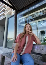 Buzo de hilo color ladrillo con rayas verticales en beige y marrón.