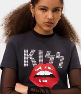 Remera baby tee de algodón color negro, con cuello redondo y mangas cortas. Presenta una estampa frontal con el logo de la banda KISS en pedrería brillante y un gráfico de labios rojos en el centro.