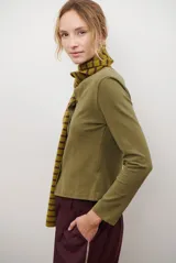 Cardigan negro de algodón con cuello redondo, cierre frontal de botones y costuras en contraste color ocre.