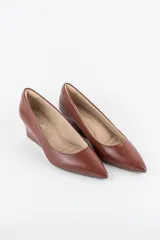 Zapatos cerrados de ecocuero color marrón, con punta fina y taco corrido.