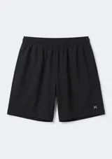 Bermuda deportiva negra con cintura elástica y bolsillos laterales, con pequeño logo reflectante en la pierna izquierda.