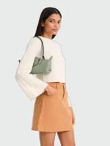 Cartera de hombro de cuero color verde menta, modelo Le Pliage Xtra S de Longchamp, de formato horizontal y estructura compacta, con asas superiores para llevar al hombro o en la mano, solapa con broche a presión y cierre de cremallera superior.