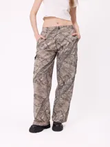 Pantalon cargo de corte recto y tiro medio, con estampado de camuflaje tipo bosque en tonos beige y marrones. Cuenta con bolsillos laterales tipo cargo con solapa y cierre de botón.