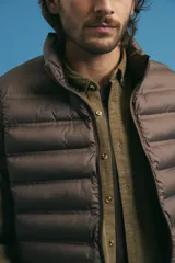 Chaleco acolchado de diseño capitoneado con cierre frontal al tono, cuello alto y ribetes en sisas y ruedo.